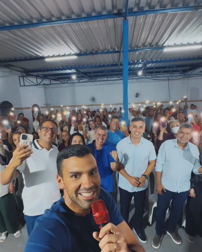 Serginho Vidigal em selfie com uma multidão acenando com lanternas de celular acesas